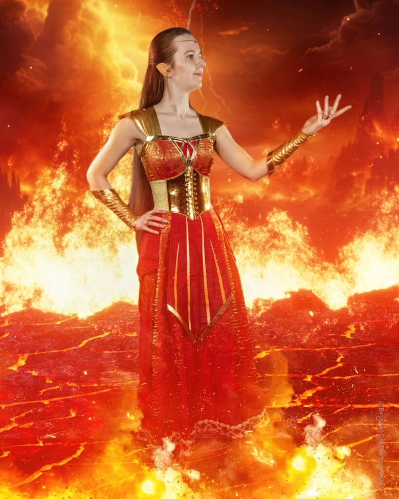 Full body photo of Riverly Twardy wearing her Kyndara cosplay, with professional editing and digitally added fire effects.